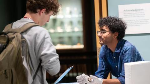 two people in a natural history museum, reviewing a specimen