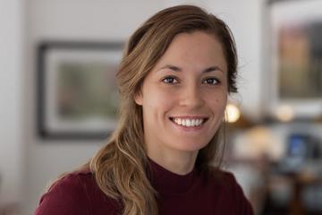 a person smiling at the camera, in an office