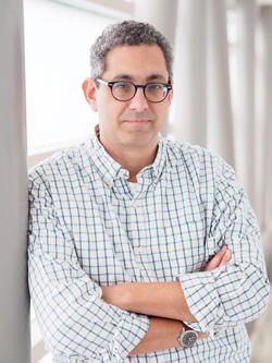 a person looking at the camera, in front of a bright window