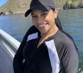 a person standing on a boat with an island in the background