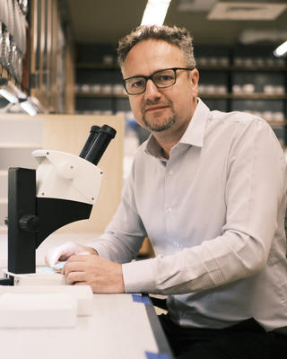  a person sitting at a table with a microscope