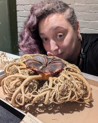 a person standing behind a large marine invertebrate specimen