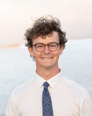 a person standing outside, smiling at the camera