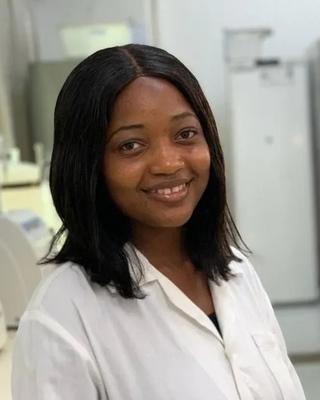 a person smiling at the camera, in a laboratory