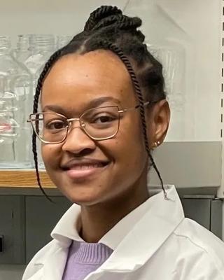  a person smiling at the camera in a laboratory