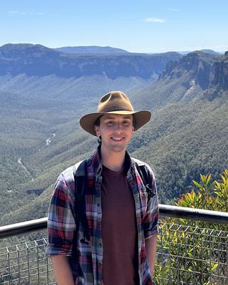 a person smiling at the camera, at a canyon overlook