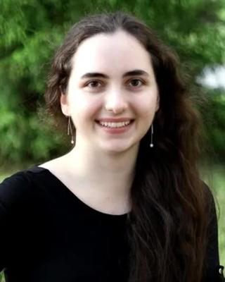 a person smiling at the camera, outside