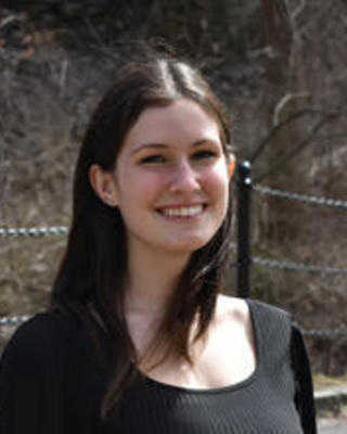a person smiling at the camera, outside