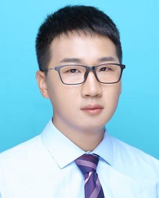 a person looking at the camera, in front of a blue background