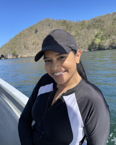 a person standing on a boat with an island in the background