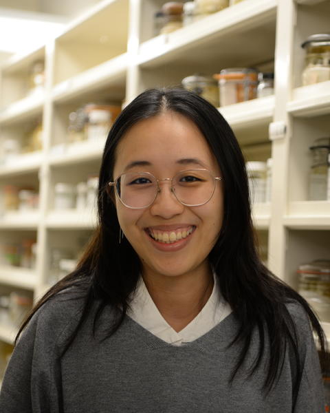 a person standing in front of shelves of glass jars