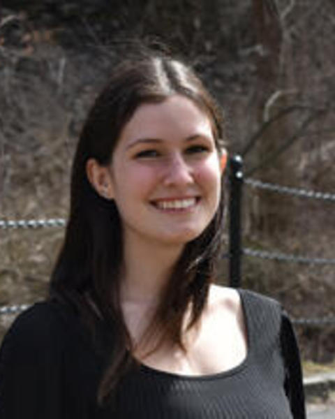 a person smiling at the camera, outside