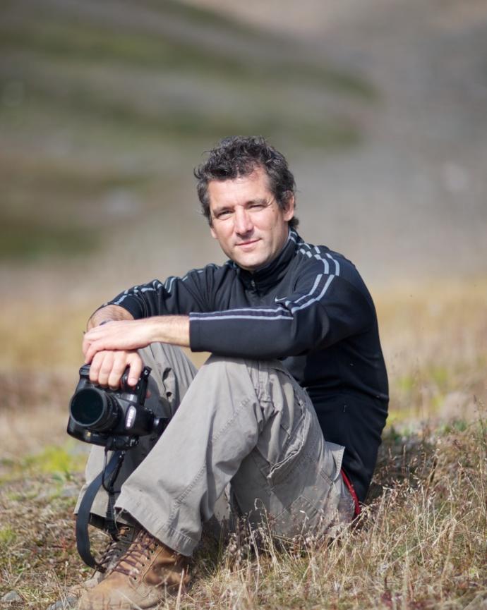 a person sitting on a hill holding a camera