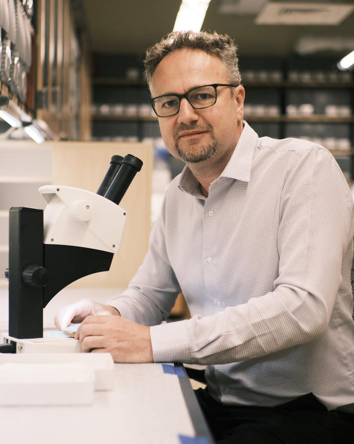 a person sitting at a table with a microscope