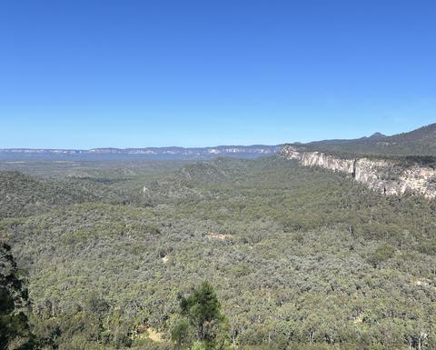 a wide green valley with cliffs on each side